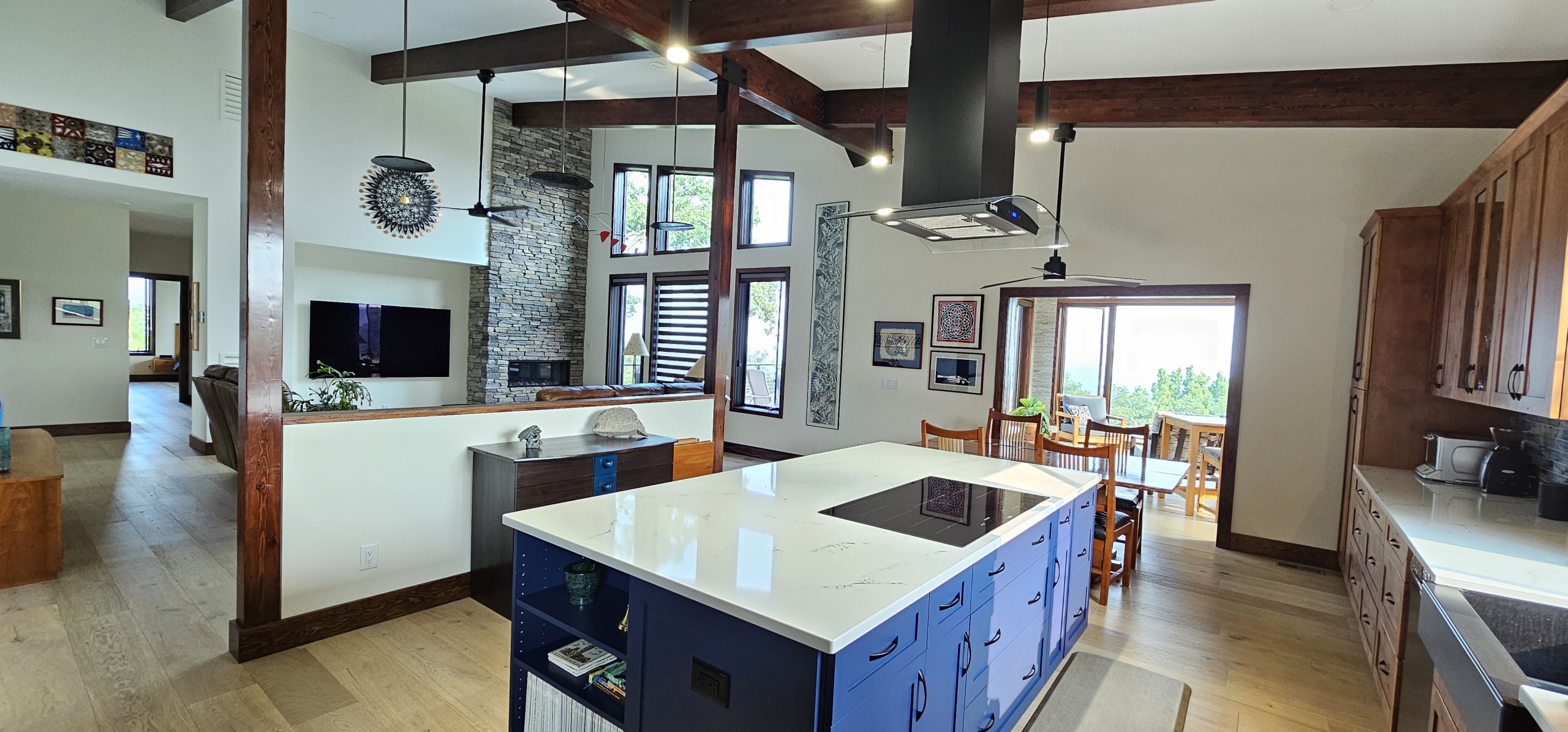 Blue kitchen island looking into living room with wood beams