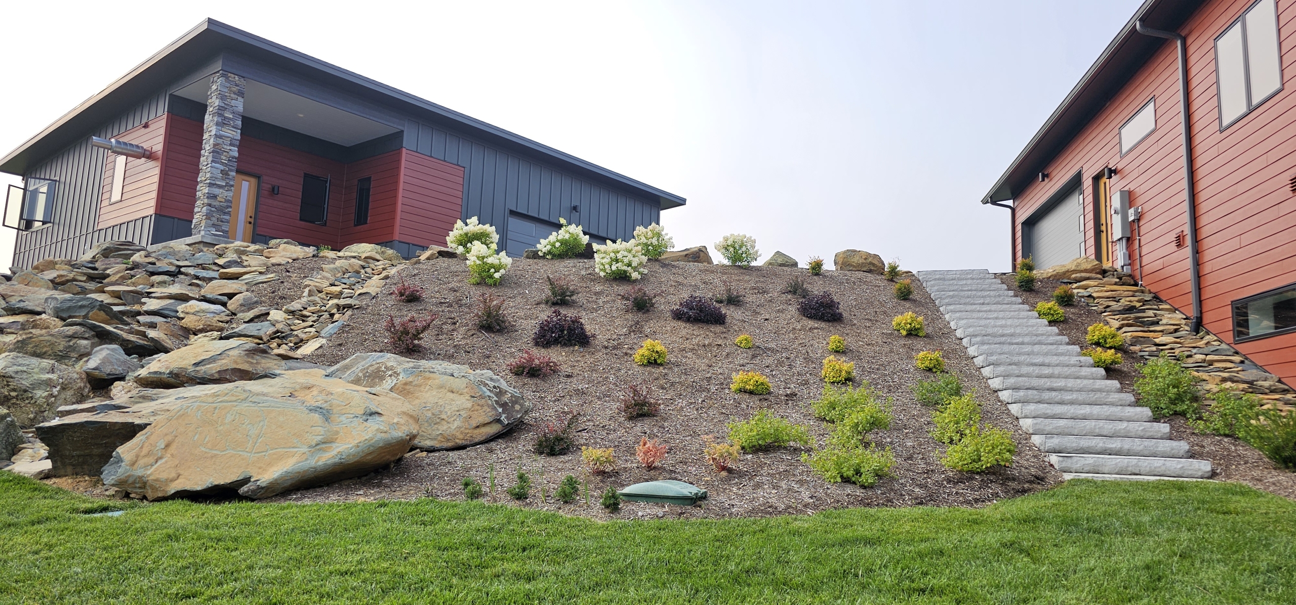 custom home exterior with hillside landscaping