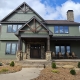 front entry to house with timber truss and green siding